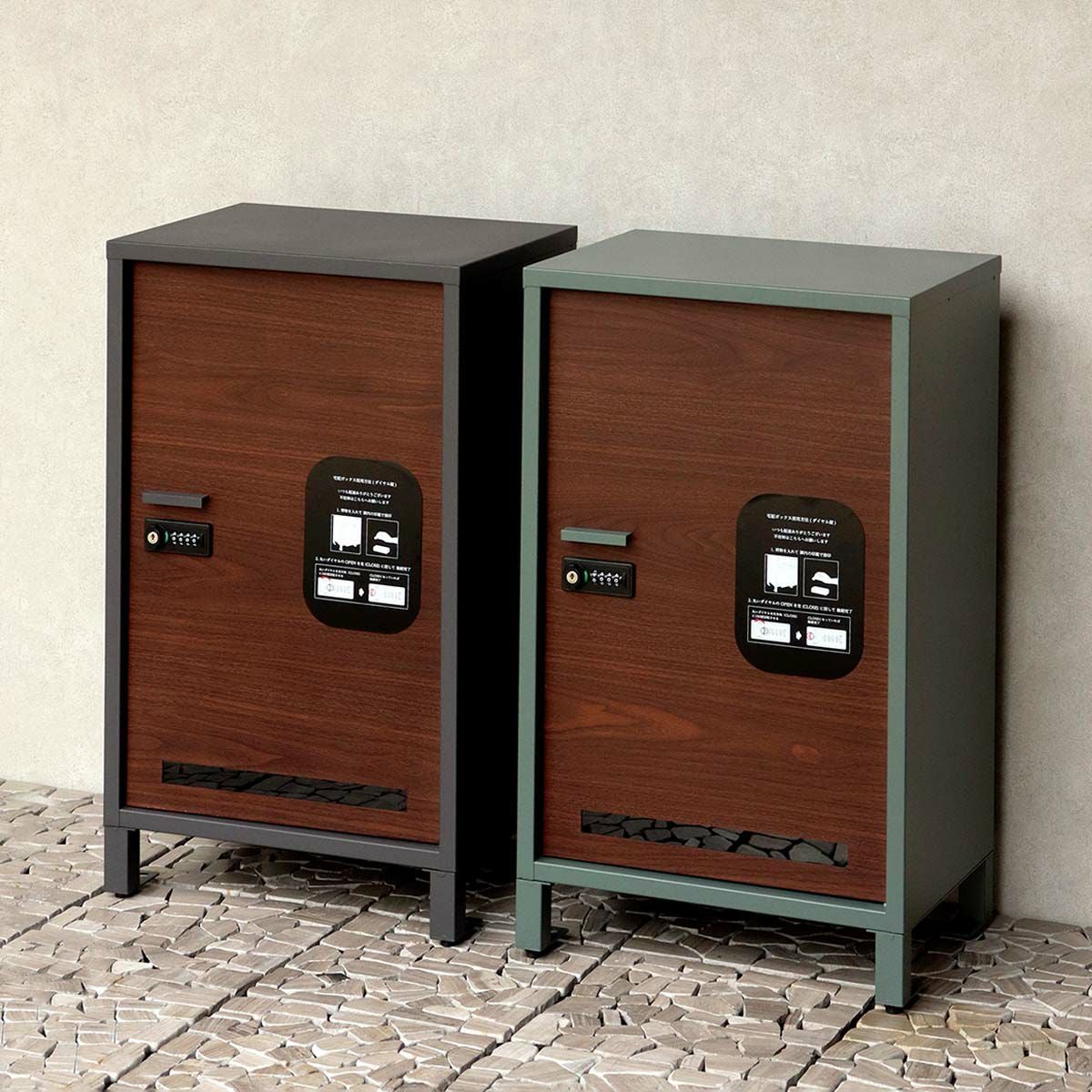 宅配ボックス2色が横並びになった設置イメージ。白い壁と石畳に置かれている。