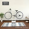 ホワイトの自転車スタンドが室内に置かれているイメージ画像。スタンドには自転車が1台かけられている。