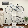 ホワイトの自転車スタンドが室内に置かれているイメージ画像。スタンドには自転車が2台かけられている。
