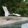プールサイドにホワイトのラウンジチェアとフットレストが設置された画像です。本商品にはフットレスト、小物は付属していません。
