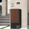 宅配ボックス本体はブラック、扉のパネルのカラーはウォールナット、幅木ブラックの設置イメージ。置くだけで玄関がスタイリッシュに