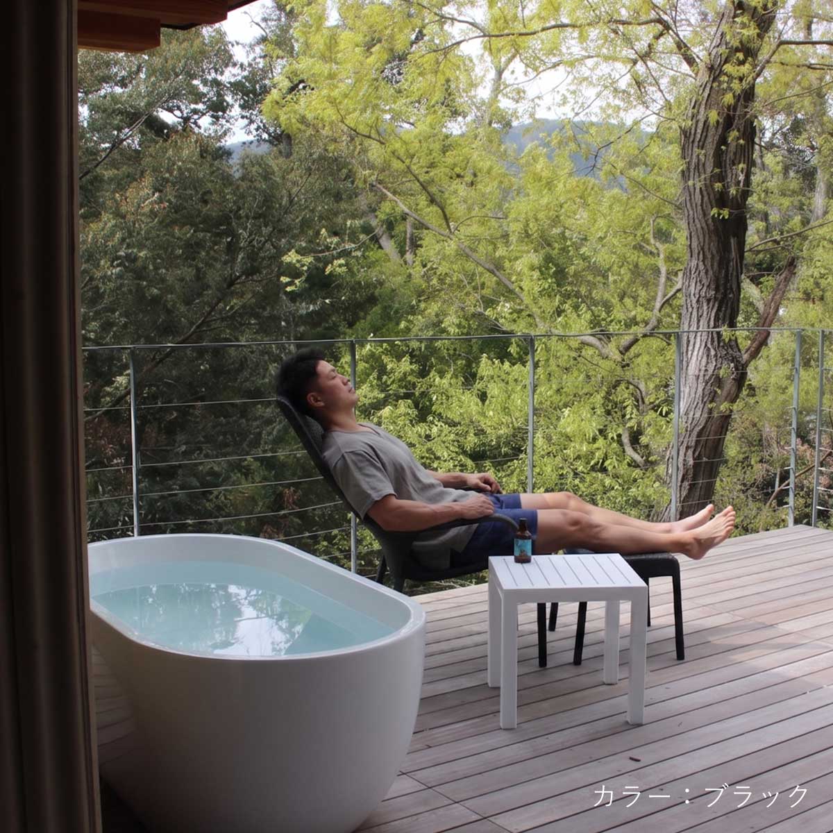 サウナの外気浴スペースでCORY（コーリー）ハイバックチェアとオットマンを使用している男性の使用イメージ画像。チェアとオットマンを組み合わせることで全身をゆったりと預けた深いととのい体験ができます。