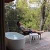 サウナの外気浴スペースでCORY（コーリー）ハイバックチェアとオットマンを使用している男性の使用イメージ画像。チェアとオットマンを組み合わせることで全身をゆったりと預けた深いととのい体験ができます。