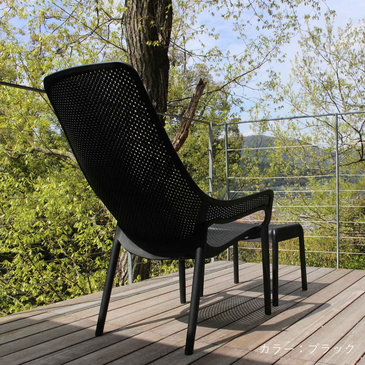 木製デッキの上にブラックカラーの「CORYハイバックチェア」とオットマンが設置された、上質な屋外空間の使用イメージ画像です。