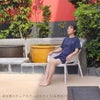 サウナの水風呂の横で女性がコーリー アームチェアに座り、外気浴を楽しんでいる設置イメージ画像。